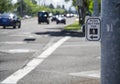 Pedestrian cross walk sign and button on busy street with cars a