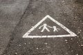Pedestrian crossing marking inside triangle on wet road with two figures walking Royalty Free Stock Photo