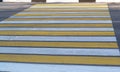 Pedestrian crossing over the roadway in the form of yellow and white stripes Royalty Free Stock Photo