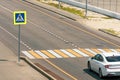 Pedestrian crossing with a road sign through the city road, the white car stopped before the crossing yield to pedestrians Royalty Free Stock Photo