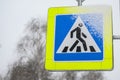 The Pedestrian Crossing sign is partially covered with snow. Road safety, blizzard in the city, winter season Royalty Free Stock Photo