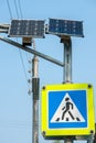 Pedestrian crossing sign, traffic lights and solar panel on city street Royalty Free Stock Photo