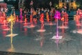 Pedestrian fountain with brightly illuminated multicolored jets of water