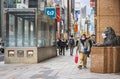 Pedestrian looking at the lion statue wearing a mask at Mitsukoshi Ginza.