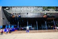 Pedestrian near mirror signboard of shopping entertainment center Maremagnum