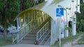 The pedestrian overpass is equipped with a modern ramp for disabled people. iron railing elements and colored glass. infrastructur