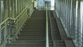 The pedestrian overpass is equipped with a modern ramp for disabled people. iron railing elements and colored glass. infrastructur