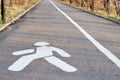 A pedestrian path with a painted sign in white paint on the asphalt Royalty Free Stock Photo