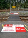 Pedestrian railroad track crossing at a rural train station in France, where signs support safety. Royalty Free Stock Photo