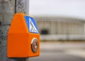 A pedestrian sign and a button.