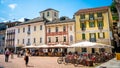 Pedestrian square with colorful houses and people at cafe outdoor terrace on Piazza Collegiate in old Bellinzona Ticino