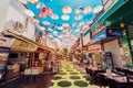 Pedestrian street with colorful multi-colored umbrellas and various souvenir shops and