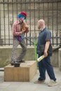 Pedestrian and street mime clown across from the Notre Dame Cathedral, Paris, France