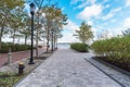 Pedestrian street in a waterfront park and blue sky with clouds in autumn Royalty Free Stock Photo