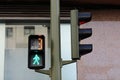 Pedestrian traffic light with green permissive signal and countdown, little green walking man, number 3, building