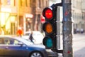 Pedestrian traffic light on the street junction in the city with beautiful bokeh, with cars and people in the background Royalty Free Stock Photo