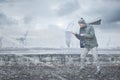 Pedestrian with an umbrella is facing strong wind and rain Royalty Free Stock Photo