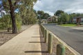 Pedestrian walkway in a quiet residential neighbourhood with some suburban houses in the distance.