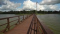 Pedestrian wooden bridge and lake water ripple under him