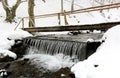 Pedestrian wooden bridge over mountain stream in winter time Royalty Free Stock Photo