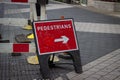 Pedestrians with arrow roadwork sign on street