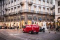 Pedestrians and car traffic on a typical shopping street in downtown Milan