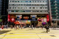 Pedestrians cross road past famous Chungking Mansions building