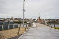 Pedestrians crossing the Derry Peace Bridge towards the walled city