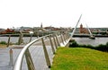 Pedestrians crossing the Derry Peace Bridge towards the walled city