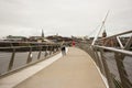 Pedestrians crossing the iconic Peace Bridge over the river foyle in londonderry city in Northern Ireland
