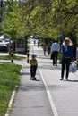 Pedestrians on footpath and boy with scooter on bicycle path Royalty Free Stock Photo