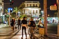 Pedestrians girls at pedestrian crossing at Tel Aviv square at night with palm trees Royalty Free Stock Photo