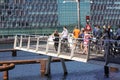 Pedestrians and people with bycycles waiting for a footbridge  to close before they can cross the water. Royalty Free Stock Photo