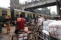 Pedestrians, rickshaws, cyclists waiting on railroad crossing in Kolkata