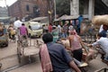 Pedestrians, rickshaws, cyclists waiting on railroad crossing in Kolkata