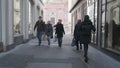 Pedestrians strolling on city sidewalk with buildings lining road surface