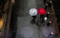 Pedestrians with umbrellas on a sidewalk in Manhattan.