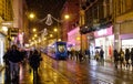 Pedestrians walk along festive street in Zagreb as tram drives through the city