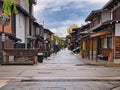 Pedestrians walk between wooden buildings in the centre of Hida Furukawa in Gifu Prefecture, Japan.