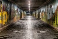 Pedestrians walking in long underpass with graffitti on walls in town Liptovsky Hradok, Slovakia