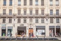 Pedestrians walking on rue de la Republique Street in Lyon, France, facing a Haussmann style building and some commercial shop