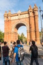 Pedestrians walking and taking pictures in front of the amazing Arch of Triomphe, located in Barcelona, Spain, Europe