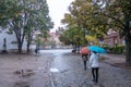 Pedestrians walking with umbrella in the center of Warsaw