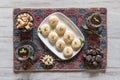 Pedha Indian sweet, Milk Fudge with tea cups in a white wooden table. Top view