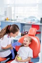 Pediatric dentist checks caries in a little girl. beautiful girl is smiling in dentist`s office. concept is a children`s medical