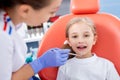 Pediatric dentist checks caries in a little girl. beautiful girl is smiling in dentist`s office. concept is a children`s medical