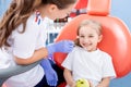 Pediatric dentist checks caries in a little girl. beautiful girl is smiling in dentist`s office. concept is a children`s medical