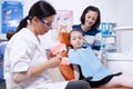 Pediatric dentist educating little girl about brushing Royalty Free Stock Photo