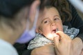 Pediatric dentist examining a little boys teeth in the dentists chair at the dental clinic. Dentist examining little boy's teeth Royalty Free Stock Photo