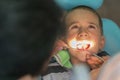 Pediatric dentist examining a little boys teeth in the dentists chair at the dental clinic. A child with a dentist in a dental Royalty Free Stock Photo